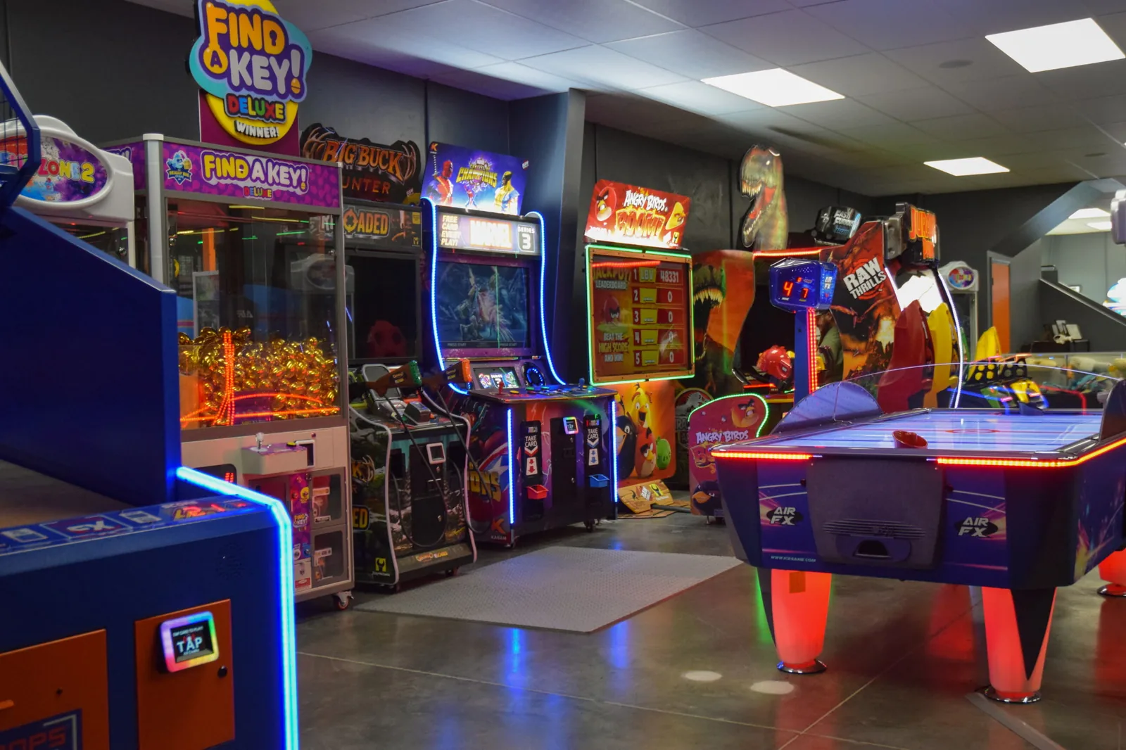 Funder Alley's arcade floor lined with claw machines, shooters, and an air hockey table
