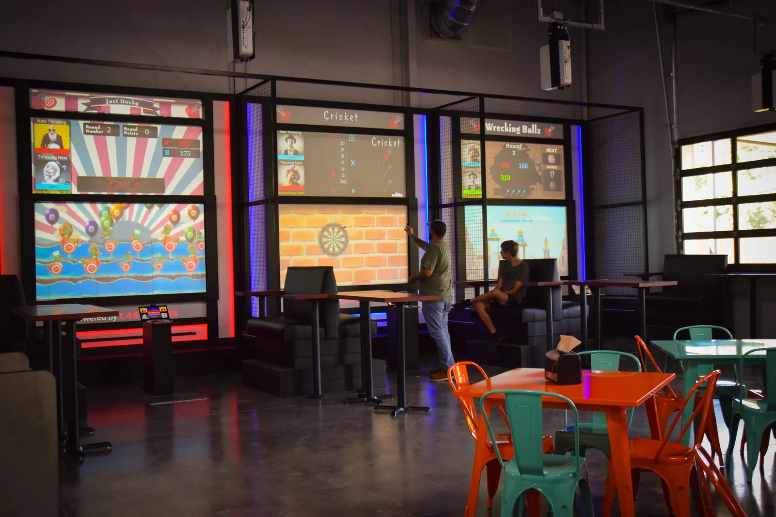 A player throwing at a Krazy Darts screen in Funder Alley's darts bays